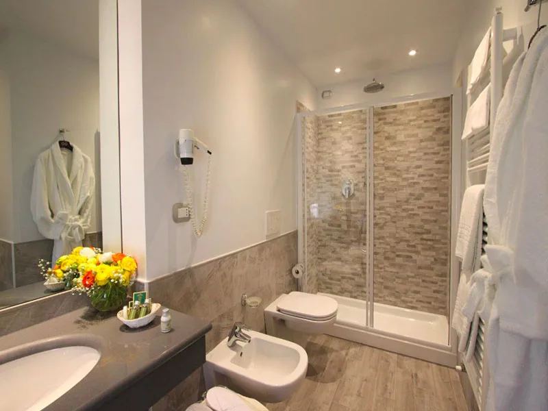 Bagno moderno con doppia doccia, bidet e lavabo con rivestimento in pietra