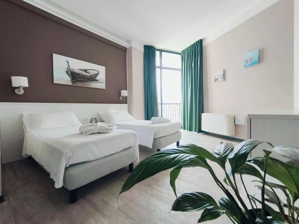 Camera dell'hotel con due letti, pareti chiare e tende verdi, arredo moderno