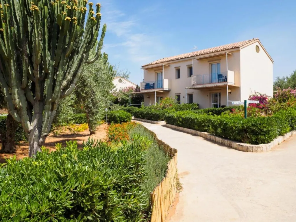 Edificio residenziale del resort con giardino, cactus e vialetto pedonale