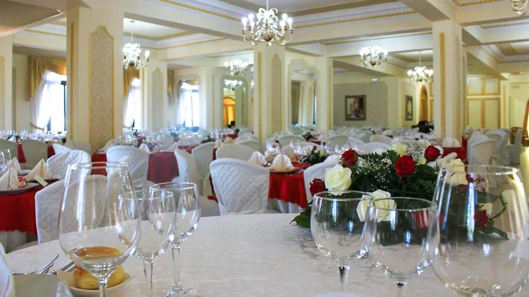 Sala ristorante elegante con lampadari, tavoli apparecchiati e fiori