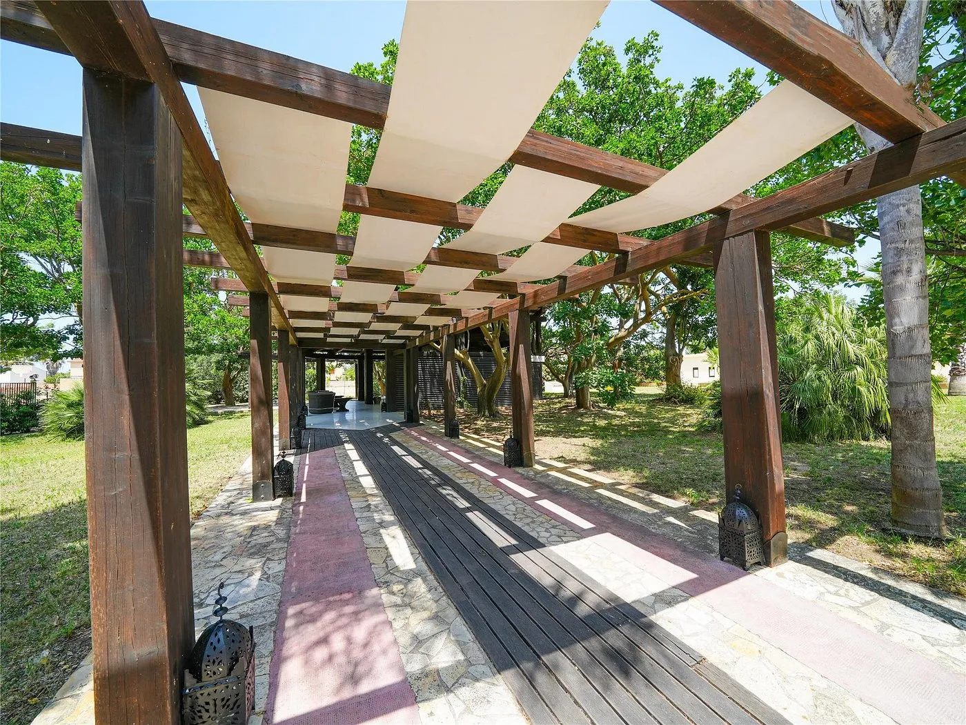 Pergolato in legno con copertura chiara nel giardino