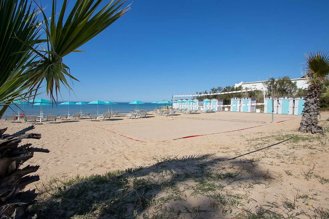 Spiaggia con campo da beach volley, lettini e cabine