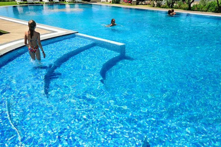 Persone che nuotano nella grande piscina dall'acqua turchese