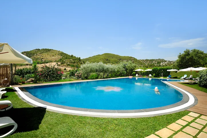 Piscina panoramica con vista sulle colline e prato verde