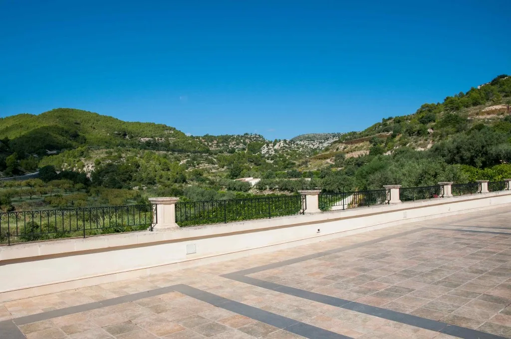 Ampia terrazza panoramica con ringhiera in ferro battuto e vista sulle colline