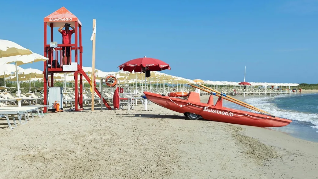 Spiaggia con torretta di salvataggio, pattino di soccorso e ombrelloni