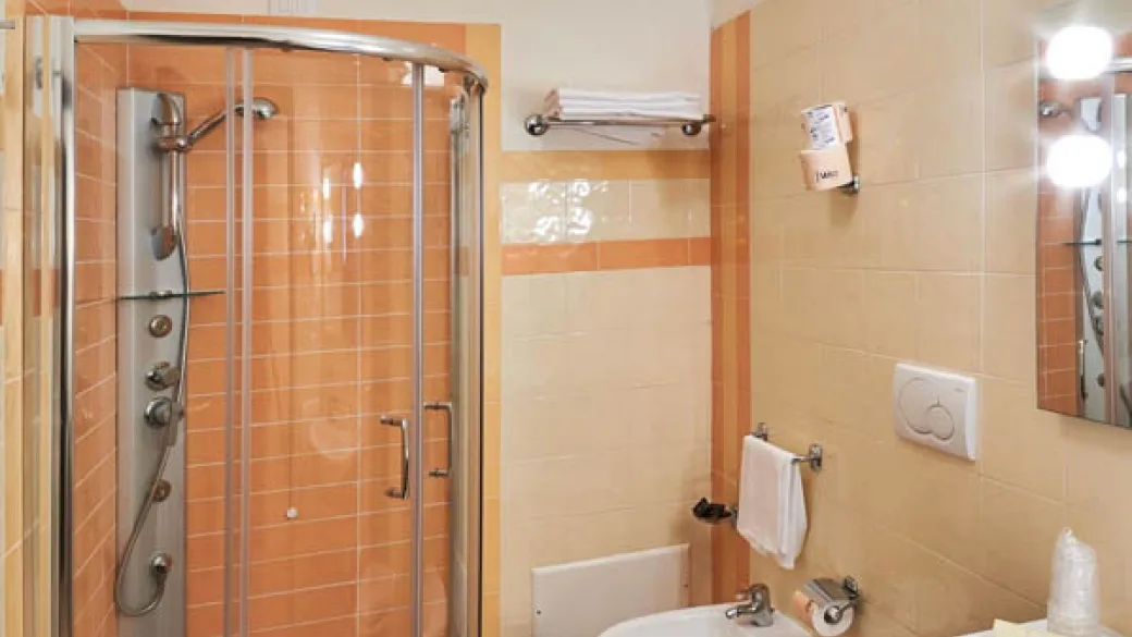 Bagno della camera con box doccia, lavabo e sanitari toni arancio