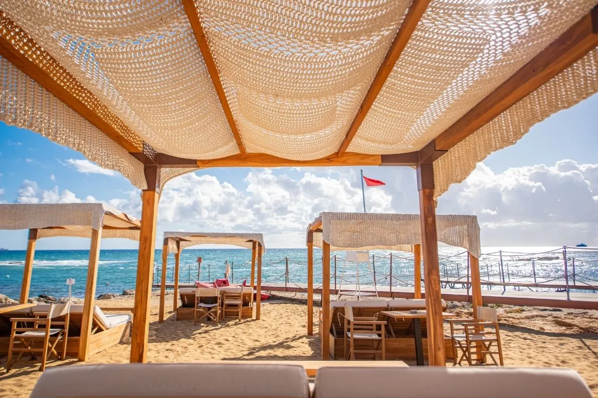 Area lounge sulla spiaggia con gazebo e tavoli vista mare