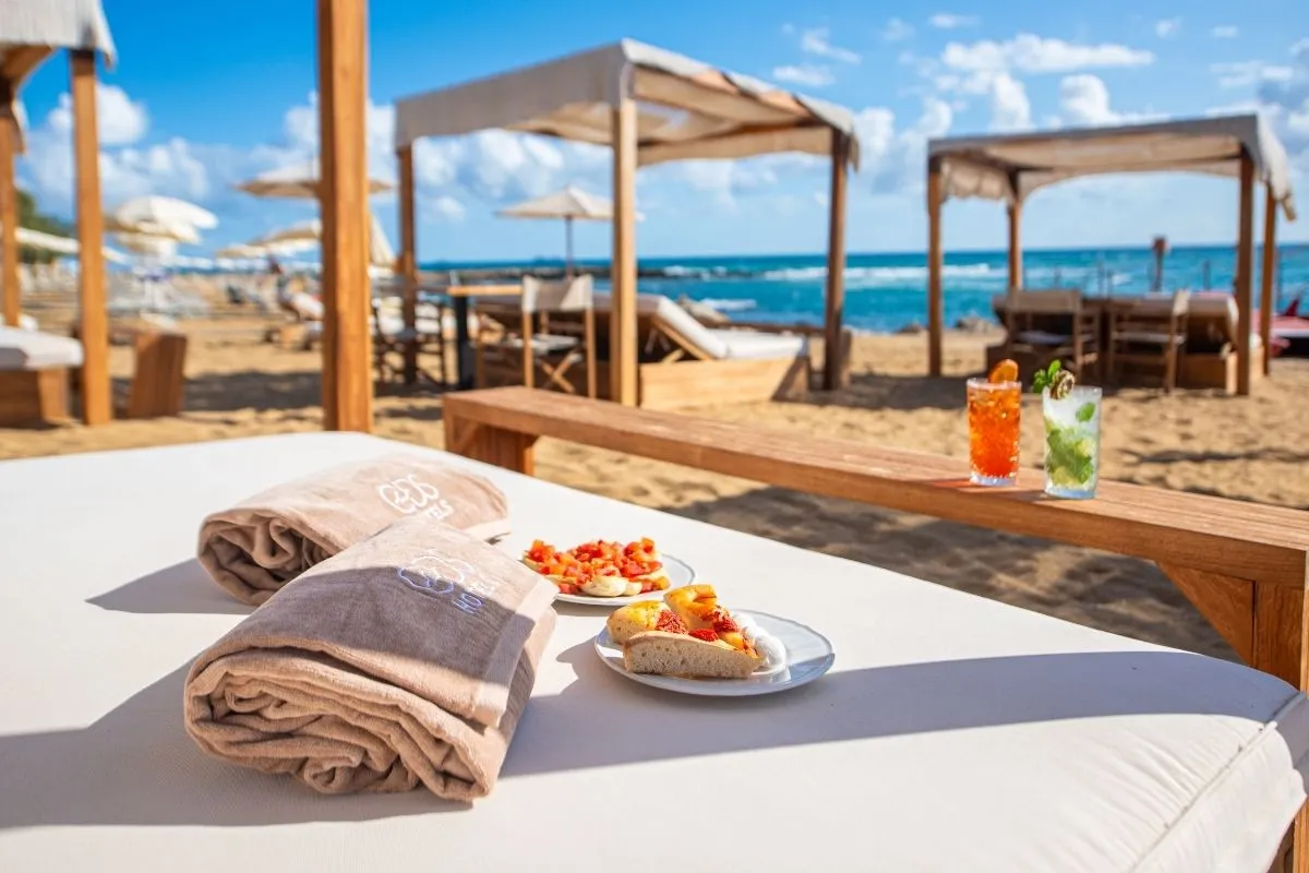 Lettino con asciugamani e aperitivo con stuzzichini in spiaggia