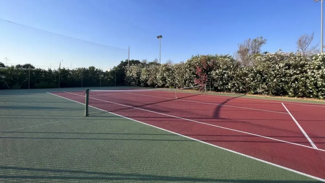 Campo da tennis circondato da vegetazione fiorita