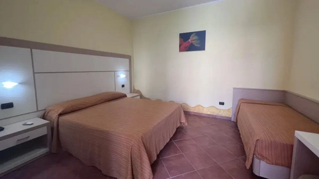 Camera tripla con letto matrimoniale e letto singolo, pareti gialle