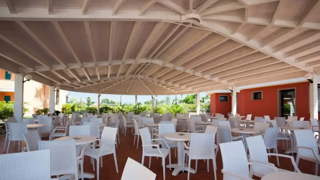 Terrazza ristorante coperta con tavoli e sedie bianche