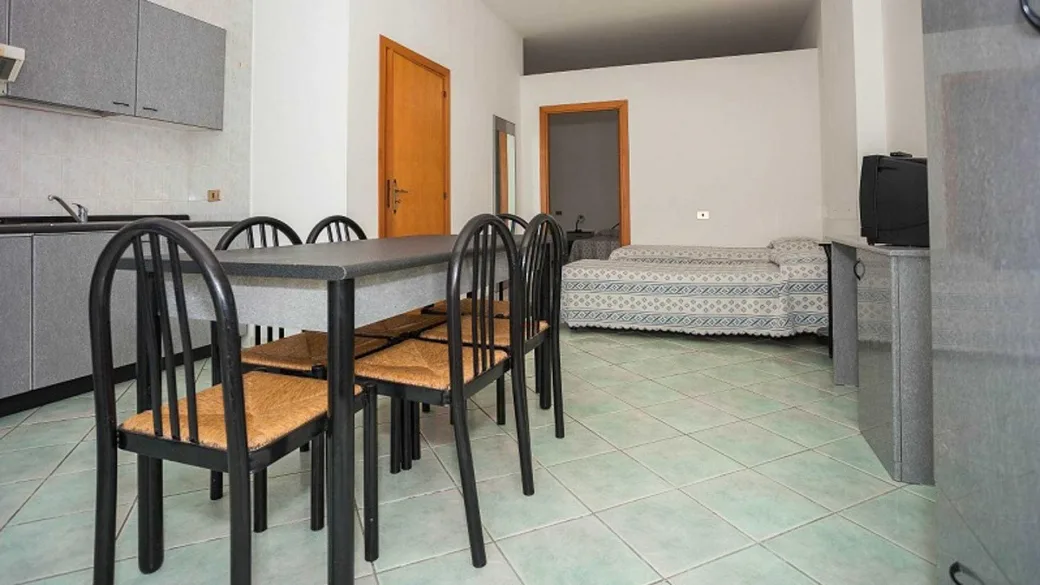 Appartamento con angolo cottura, tavolo da pranzo e zona letto