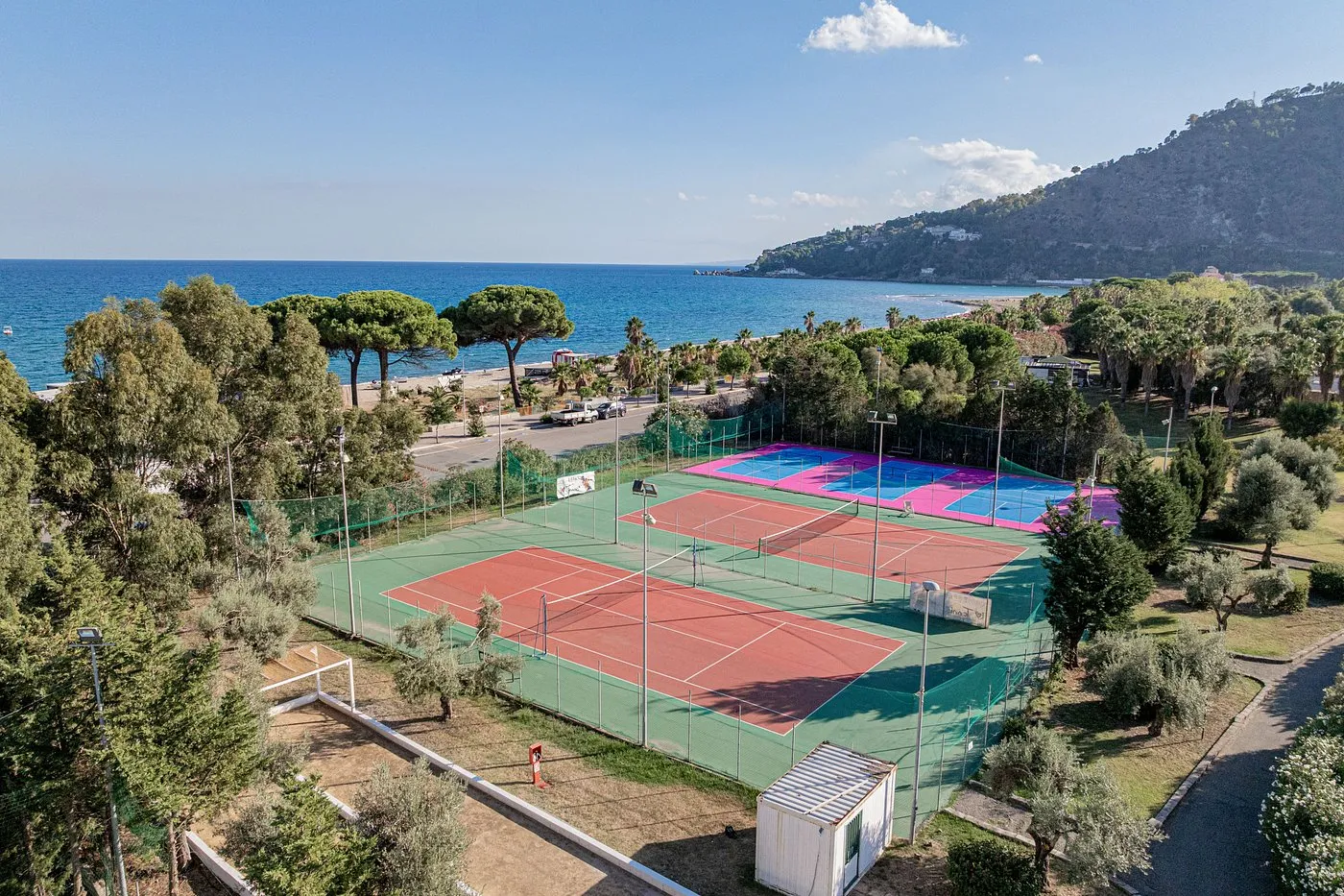 Campi da tennis e padel del resort con vista mare circondati dalla vegetazione