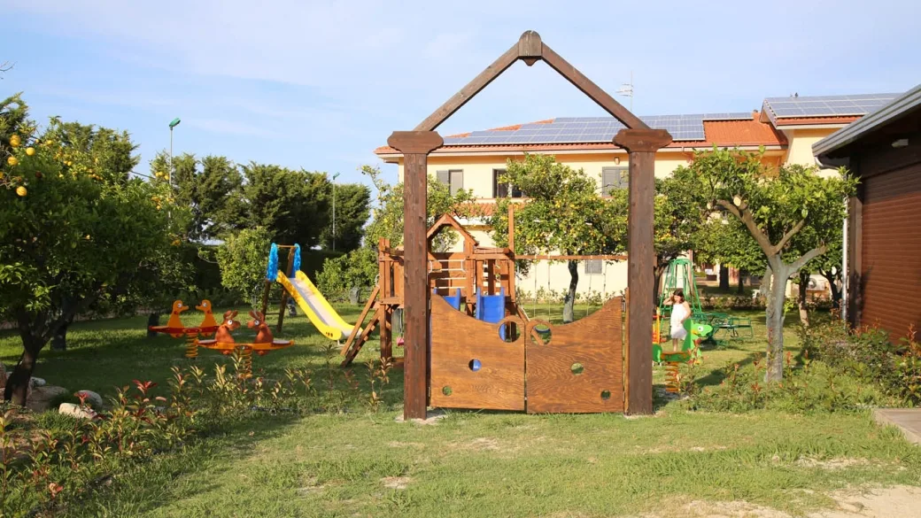 Area giochi per bambini in legno con scivolo nel giardino