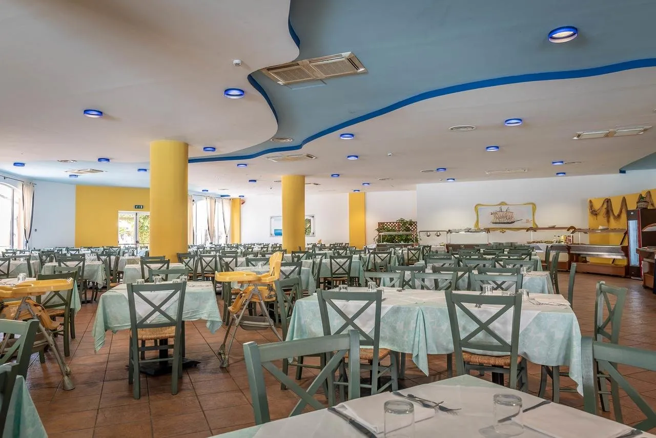 Sala ristorante con tavoli apparecchiati, sedie verdi e seggioloni per bambini