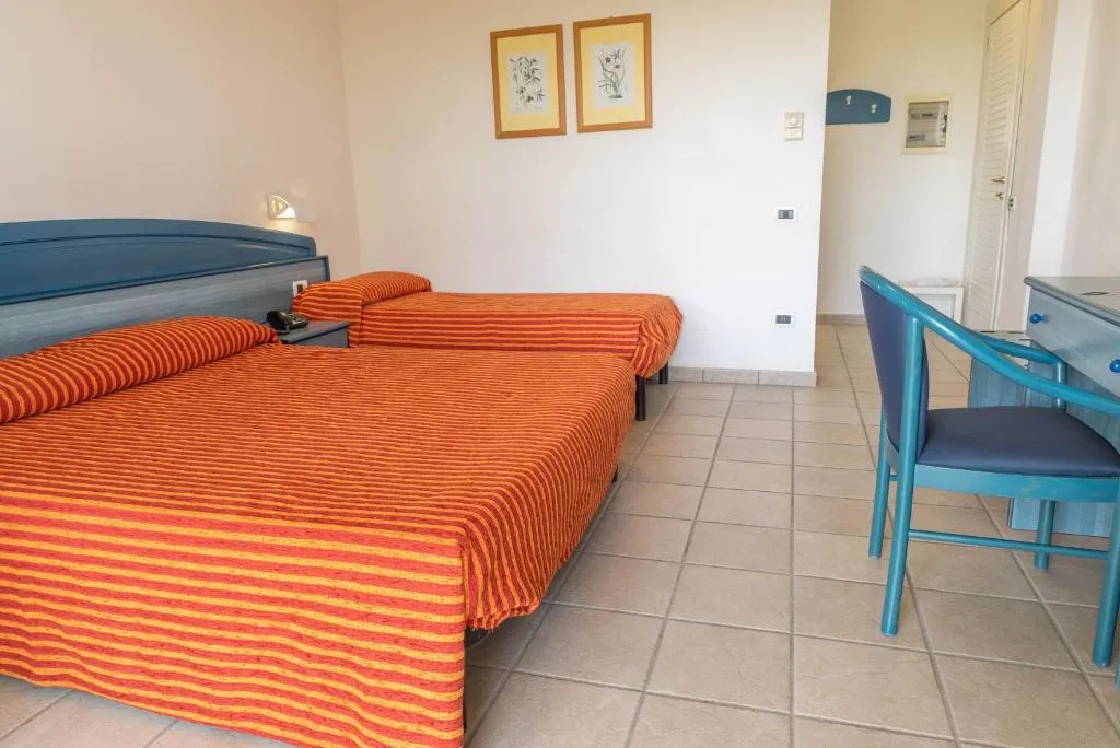 Camera con letto matrimoniale e singolo, copriletti a righe arancioni e scrivania