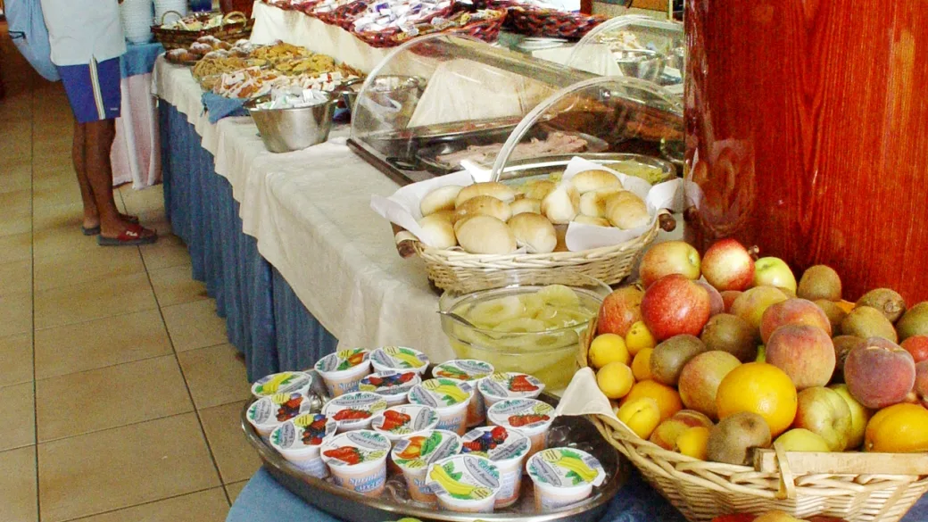 Buffet con pane, frutta fresca, yogurt e dolci esposti su tavoli del ristorante