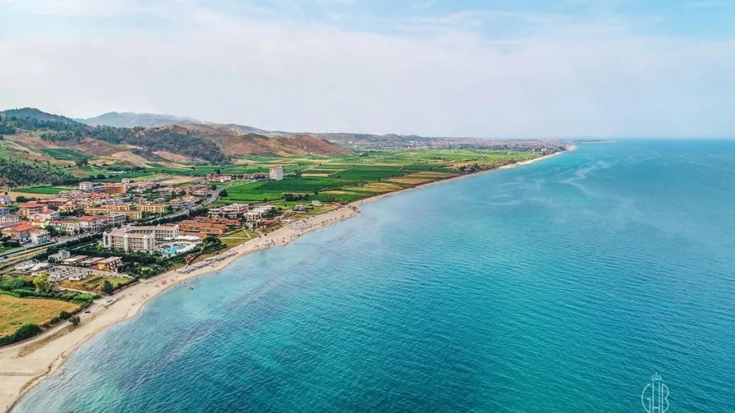 Veduta aerea della costa con colline, mare e hotel lungo la spiaggia