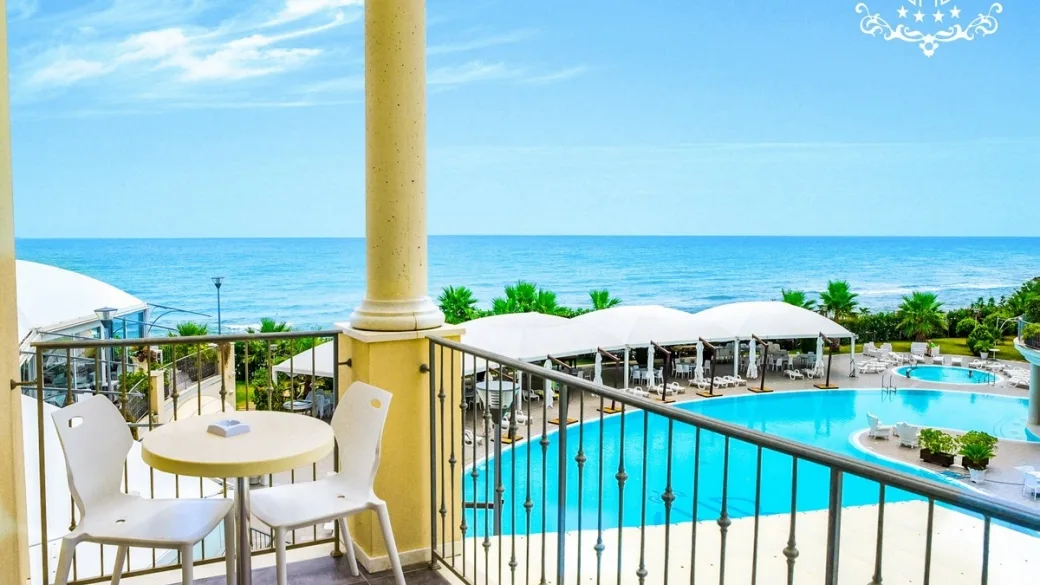 Balcone con tavolino vista mare e piscina del resort