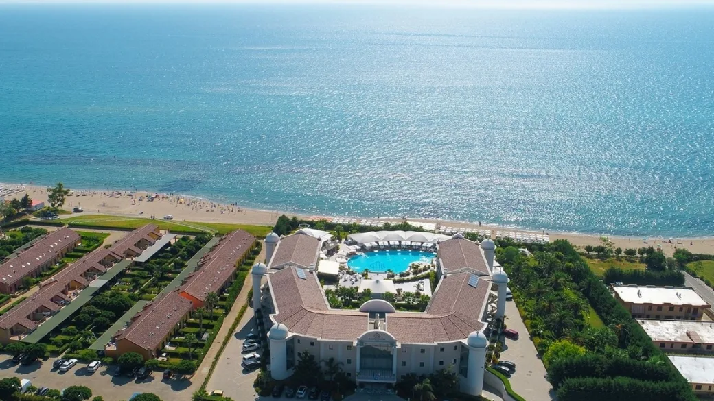Veduta aerea dell'hotel con piscina centrale affacciato sulla spiaggia
