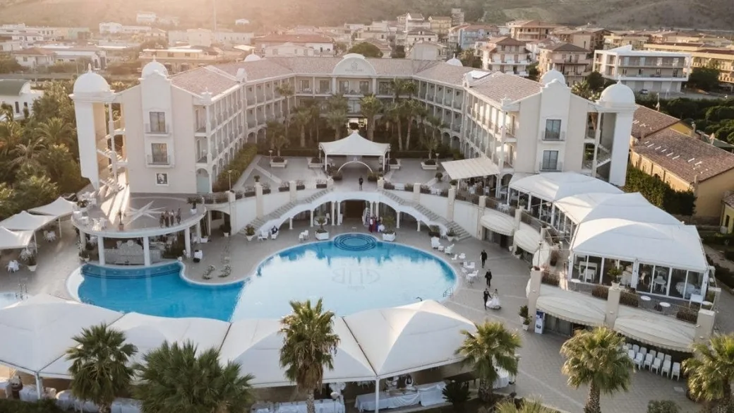 Veduta aerea del resort con allestimento eventi e piscina al tramonto