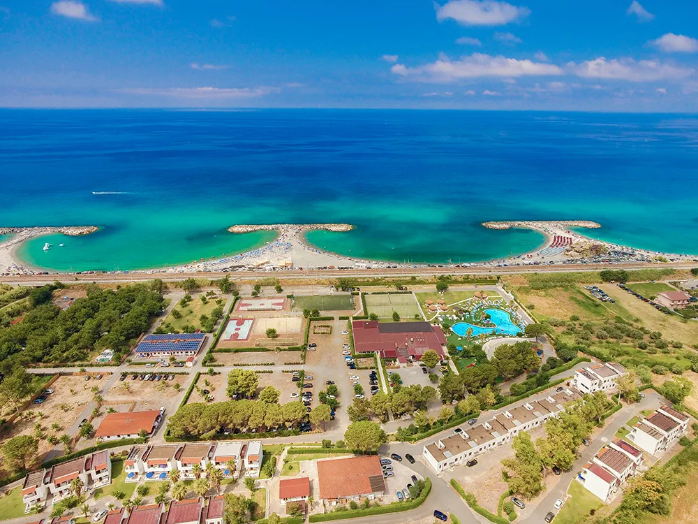 Panorama aereo del resort con spiaggia, piscine e mare turchese sullo sfondo