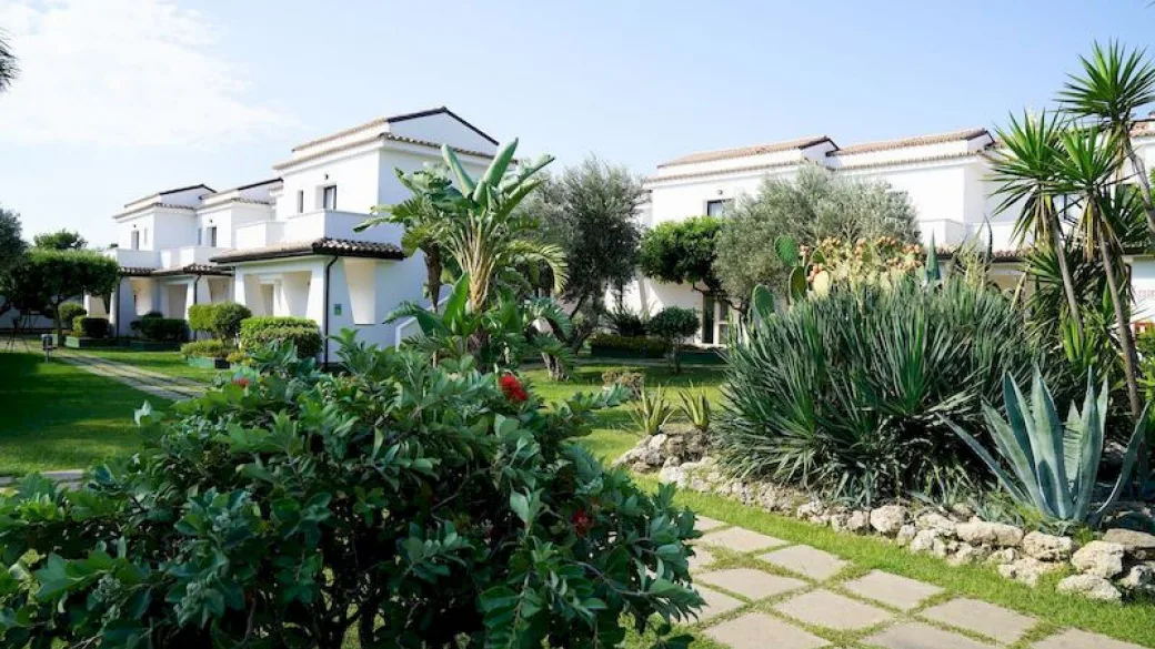 Villette bianche immerse nel giardino mediterraneo con piante e palme