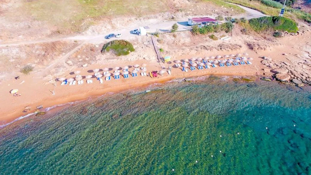 Vista aerea della spiaggia sabbiosa con ombrelloni e mare cristallino