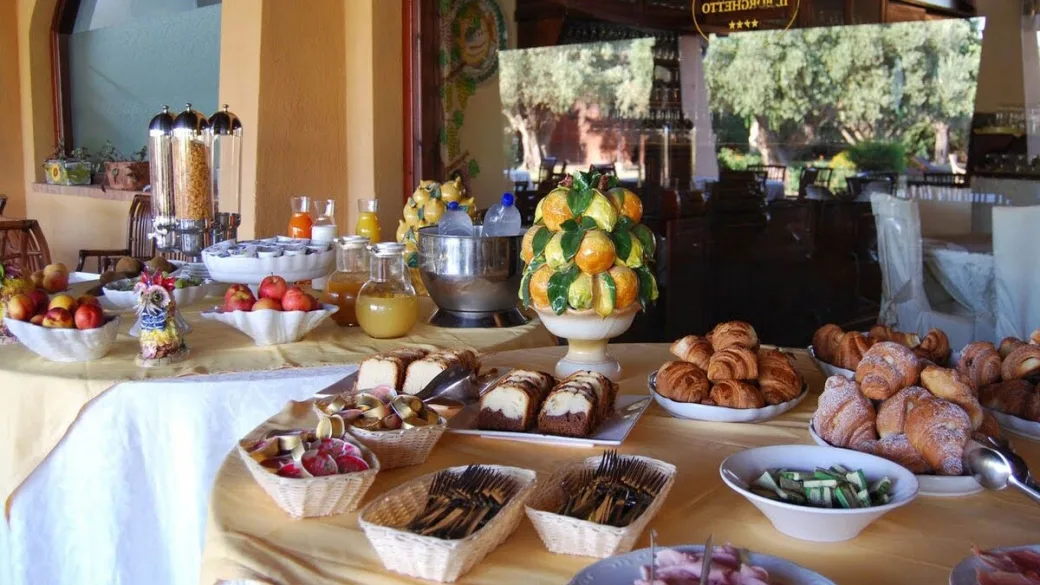 Buffet colazione con frutta, cornetti, dolci e centrotavola di agrumi