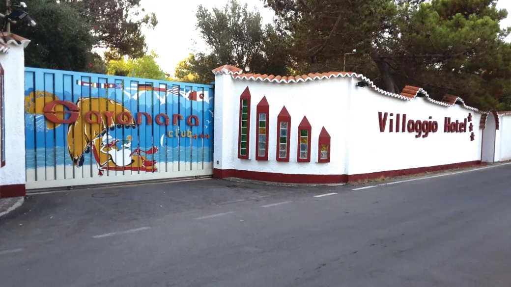 Ingresso del villaggio hotel con cancello colorato e insegna