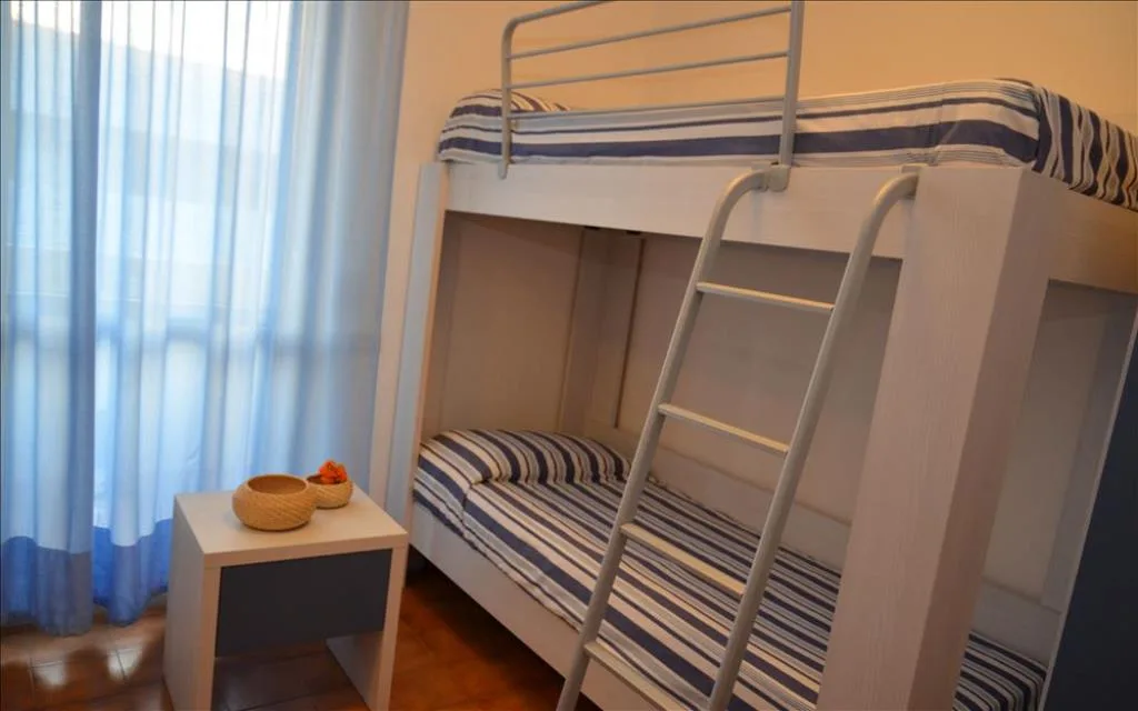 Cameretta con letto a castello e tende azzurre