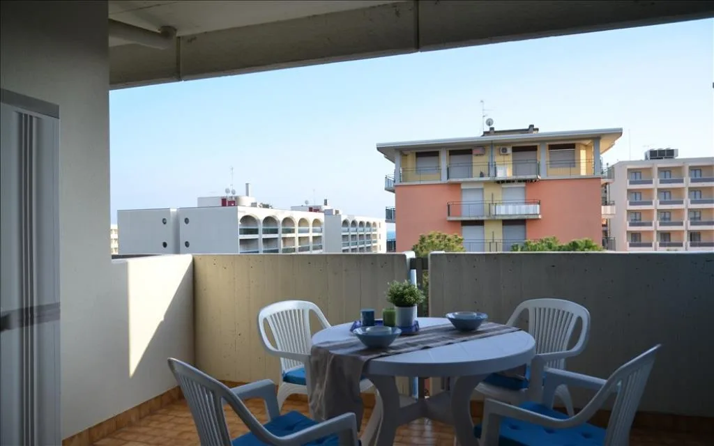Terrazza con tavolo rotondo e sedie bianche