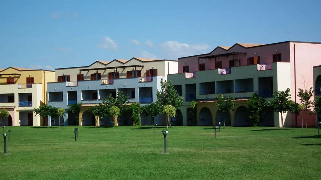Edifici colorati del residence con prato verde e giardino