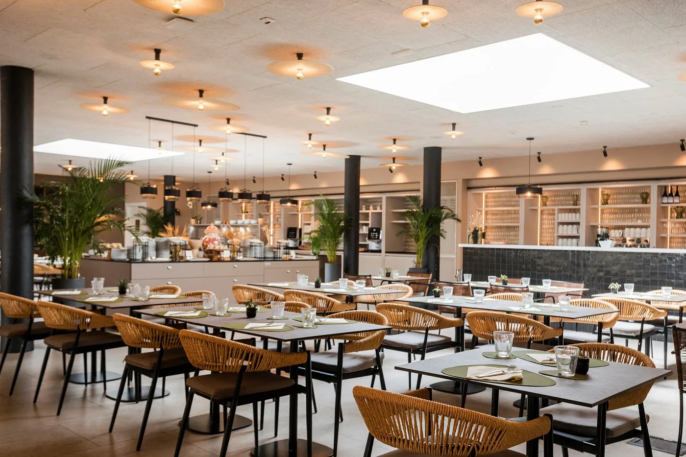 Sala ristorante interna luminosa con tavoli e sedie in rattan