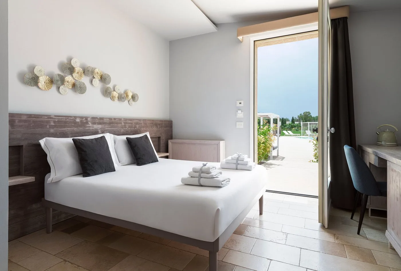 Camera moderna con letto matrimoniale e uscita vetrata sulla piscina