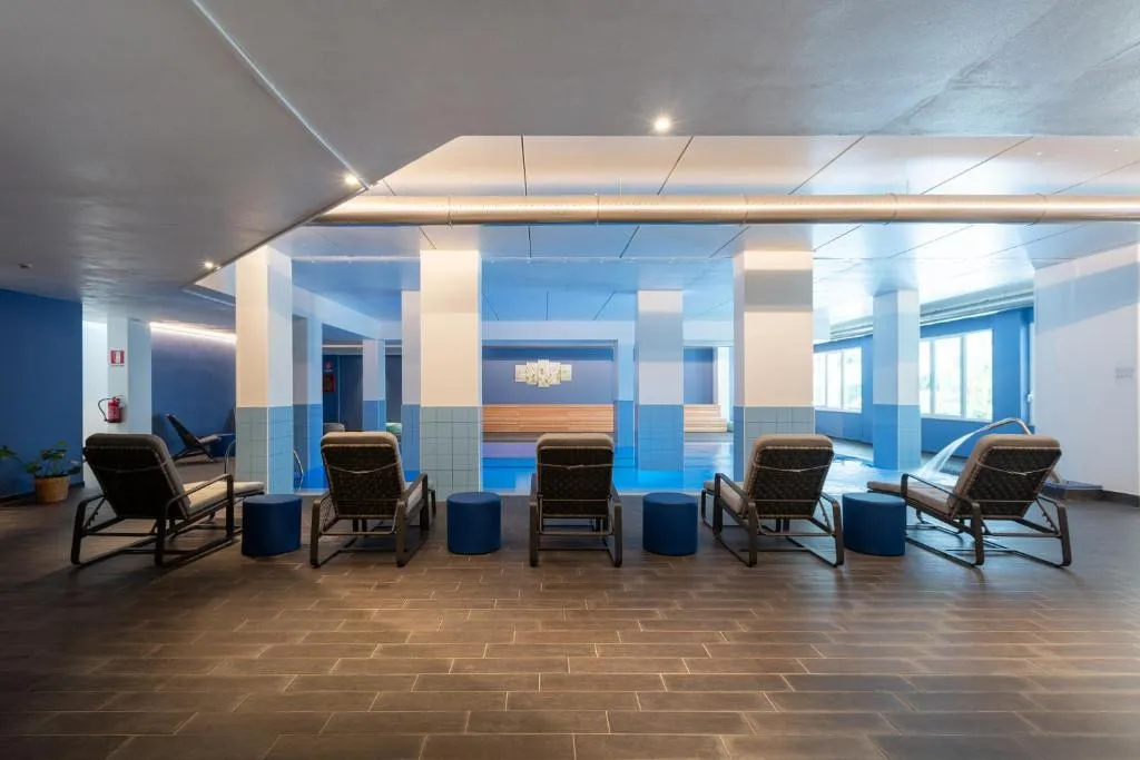 Area relax della spa con lettini e piscina interna illuminata