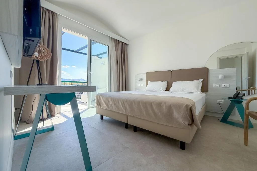 Camera moderna con letto matrimoniale, scrivania e balcone con vista