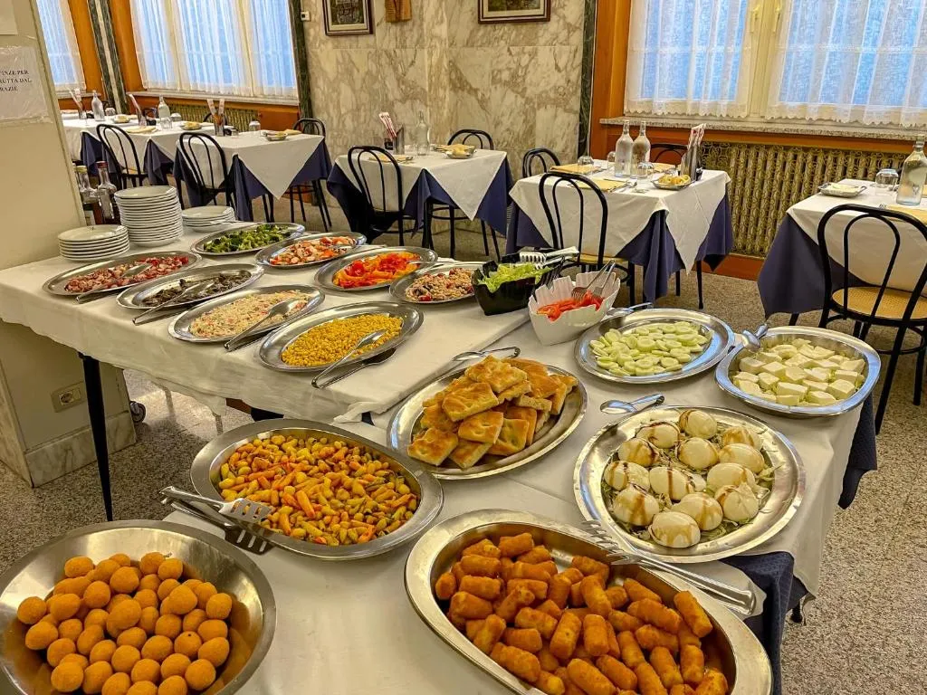 Buffet con vassoi di antipasti, salumi, formaggi e fritti nella sala ristorante