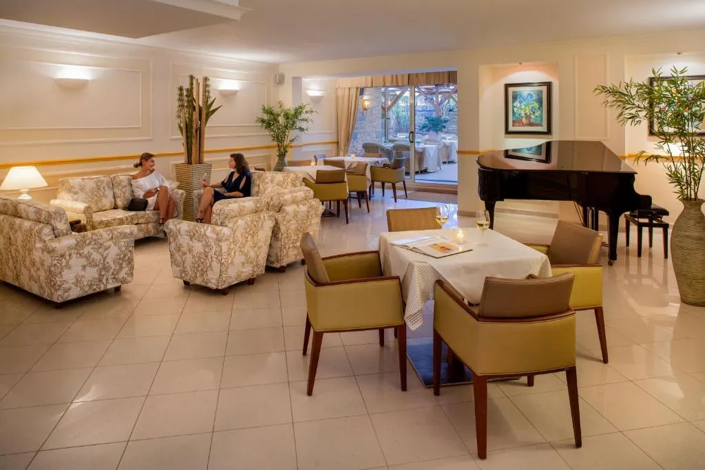 Elegante hall con divani, poltrone, pianoforte a coda e area lounge