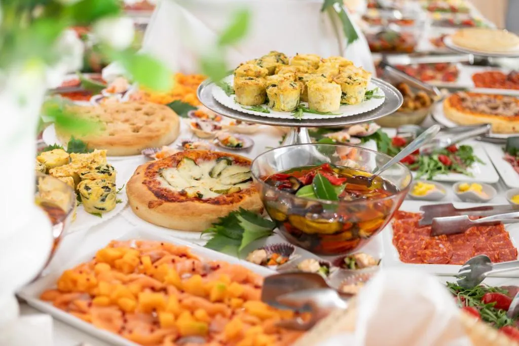 Buffet ricco di antipasti, focacce, salumi e verdure