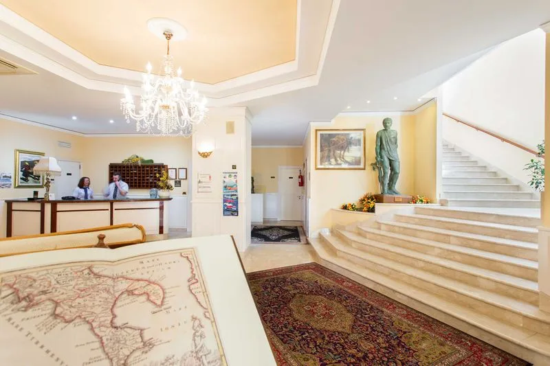 Hall dell'hotel con reception, lampadario di cristallo e scala in marmo