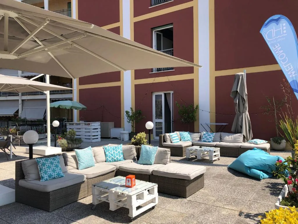 Terrazza lounge con divani in rattan, cuscini turchesi e ombrelloni