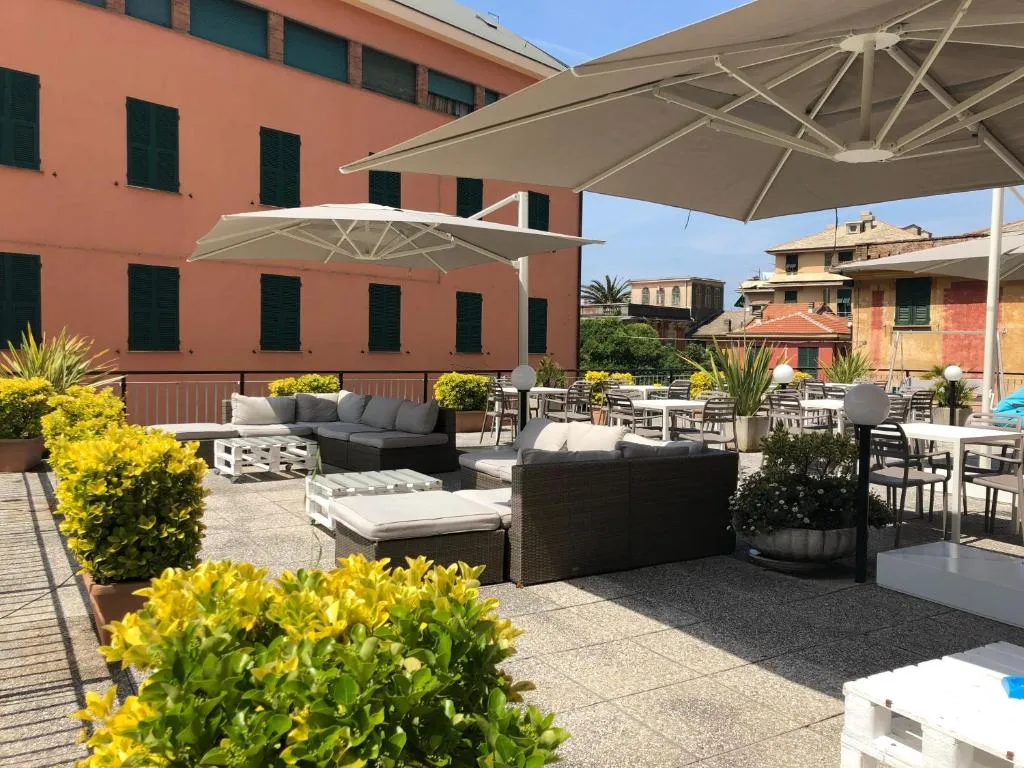 Terrazza esterna con divani, ombrelloni bianchi e piante verdi