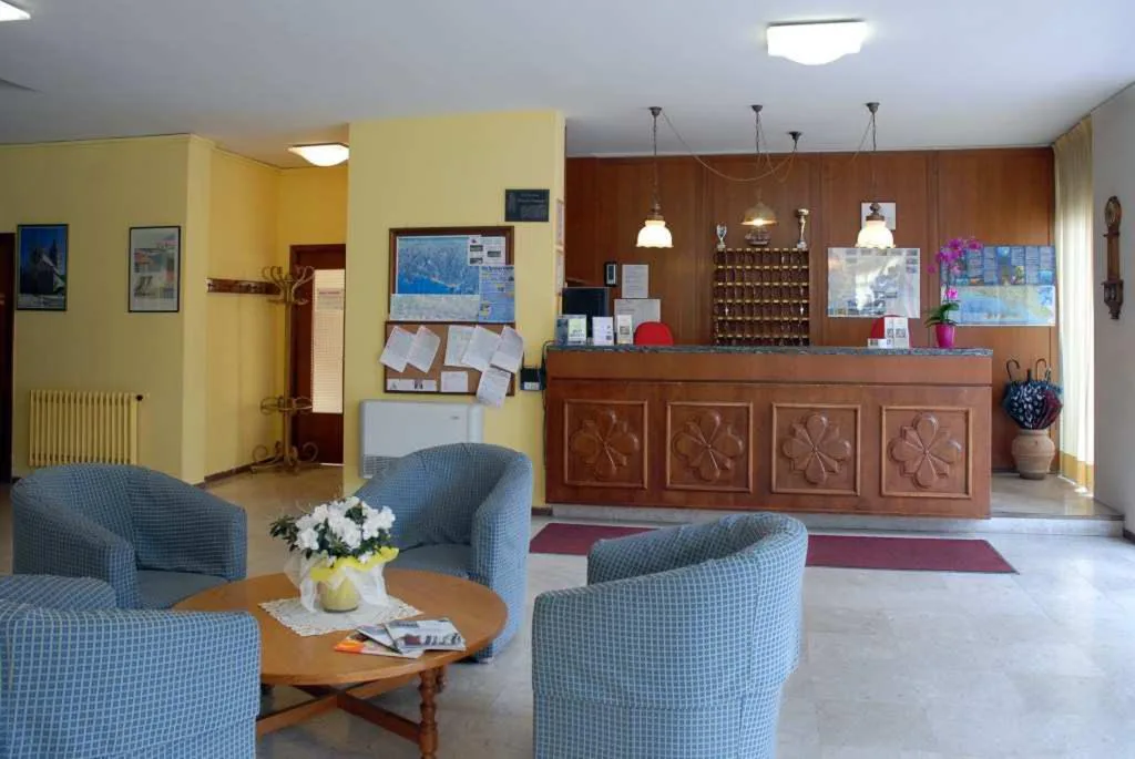 Reception dell'hotel con bancone in legno e poltrone azzurre