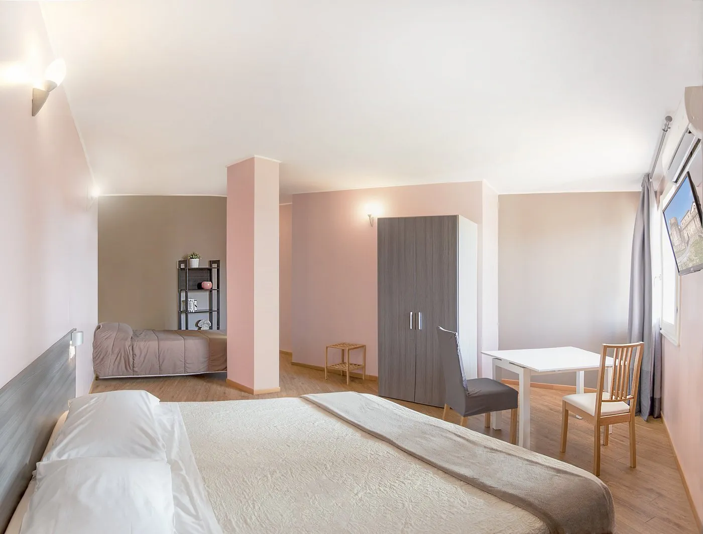 Camera familiare ampia con letto matrimoniale, letto singolo, armadio e tavolo con sedie