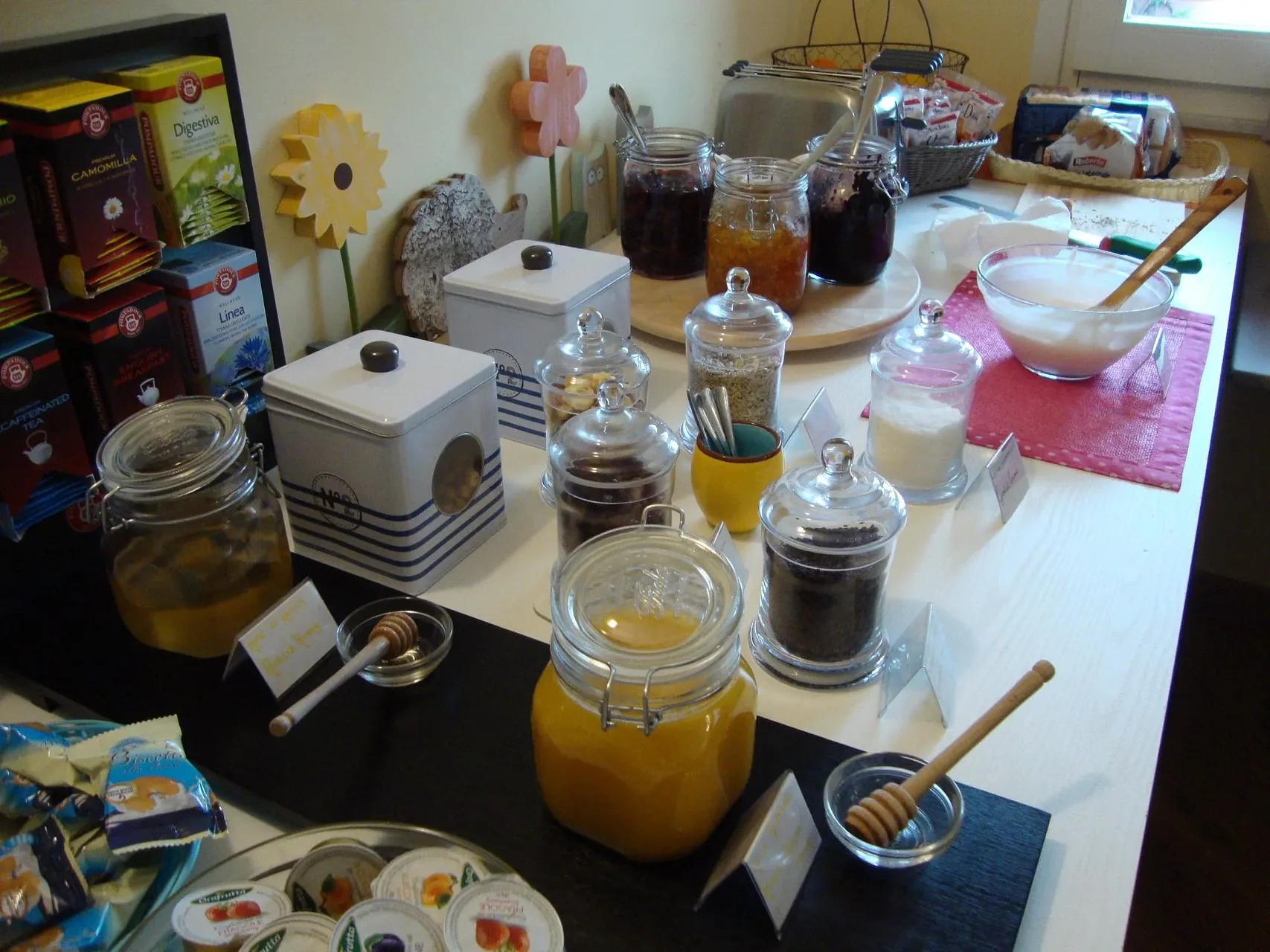Buffet della colazione con marmellate, miele, yogurt, cereali e selezione di tè