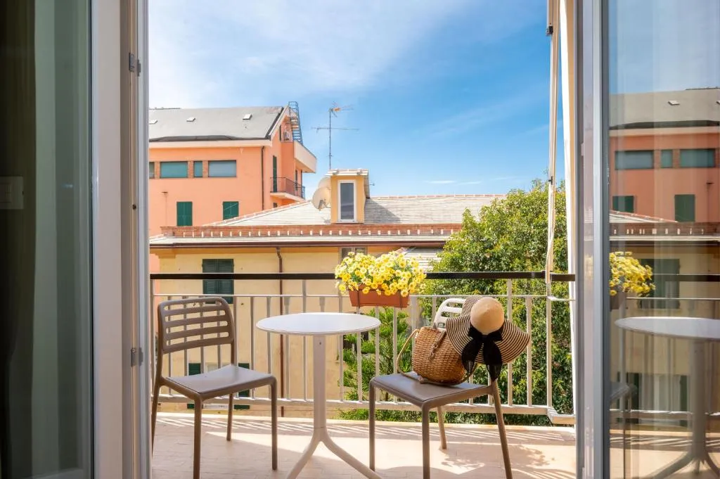 Vista dal balcone su tetti e palazzi colorati con tavolino e fiori gialli
