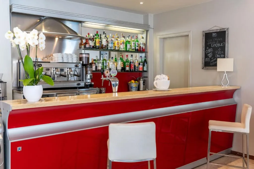 Bancone bar rosso con macchina del caffè e bottiglie di liquori
