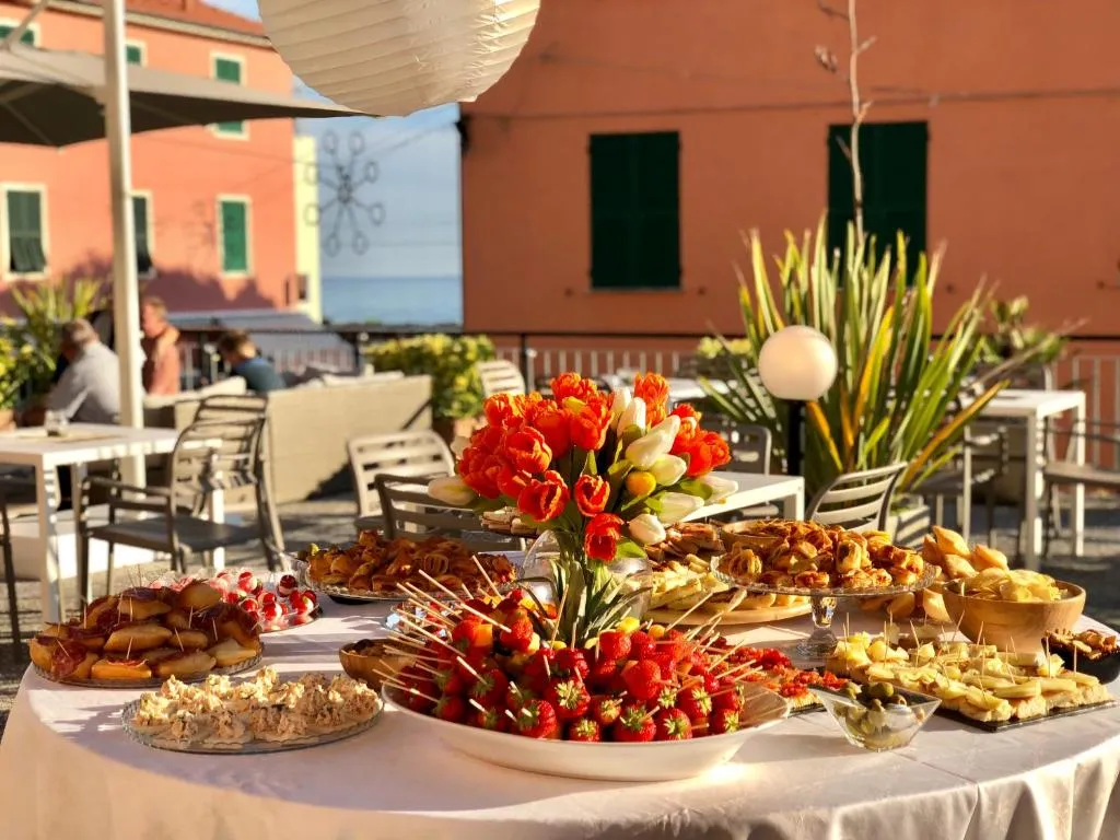 Buffet all'aperto con dolci, fragole e fiori al tramonto